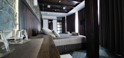 a bedroom with a bed and a table and some windows at Pidkova in Rivne