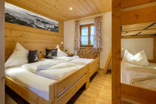 1 dormitorio con 2 camas en una cabaña en Gästehaus Mooswiese, en Ofterschwang