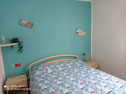 1 dormitorio con 1 cama con pared azul en La mi' Elba en Lacona