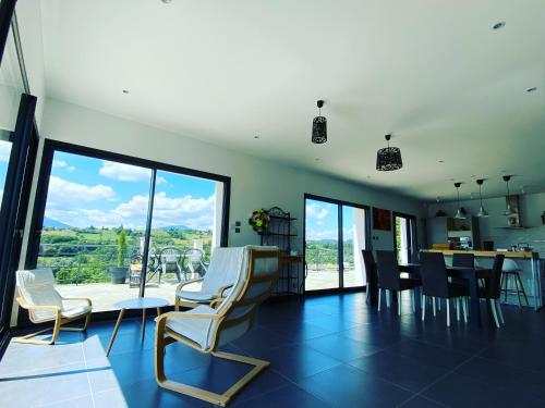 sala de estar con mesa, sillas y puertas de cristal en Villa Bellevue "Rez-de-chaussée" en Belley