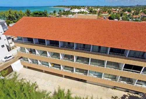 Praia dos Carneiros Flat Hotel Lindo Apto 302 في بريا دوس كارنيروس: اطلالة علوية على مبنى بسقف برتقالي