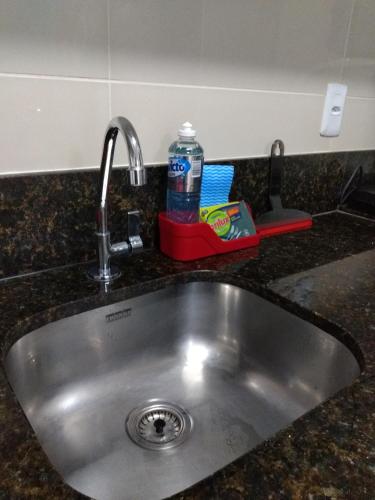 a sink with a bottle of water sitting next to it at Praia dos Carneiros Flat Hotel Fantástico in Tamandaré