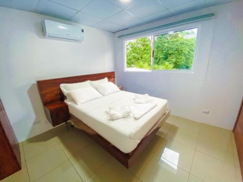 a small bedroom with a bed with a window at Puerto Viejo Lodge in Puerto Viejo