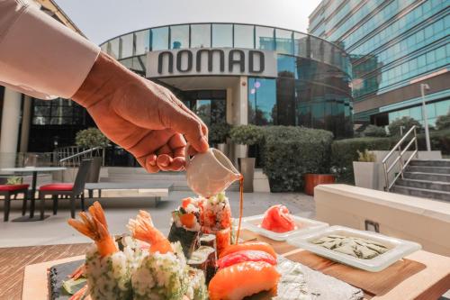 a person cutting a piece of food with a knife at Jumeirah Creekside Hotel in Dubai