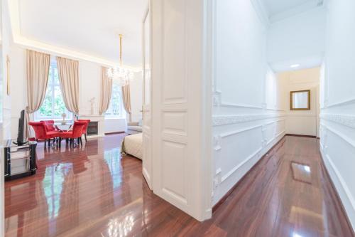 sala de estar con suelo de madera y paredes blancas en Music Academy Suite Café Vian Apartman Kft, en Budapest