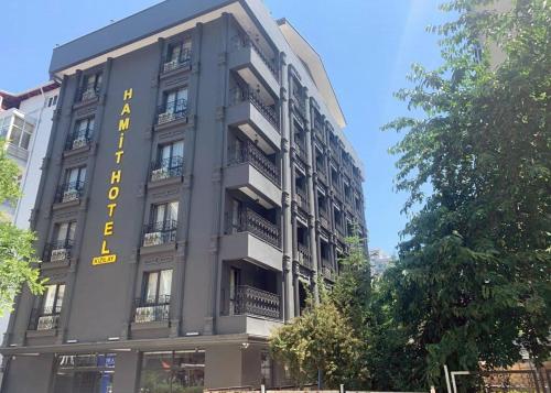a building with a yellow sign on the side of it at Hamit Hotel Kizilay in Ankara