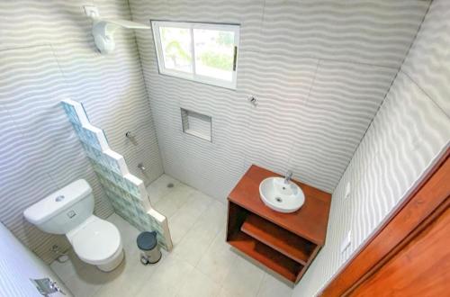 uma pequena casa de banho com WC e lavatório em Puerto Viejo Lodge em Puerto Viejo