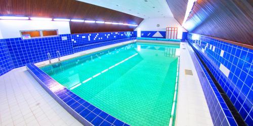 a large swimming pool in a gym with blue tiles at Bungalovy-Pustevny in Pustevny