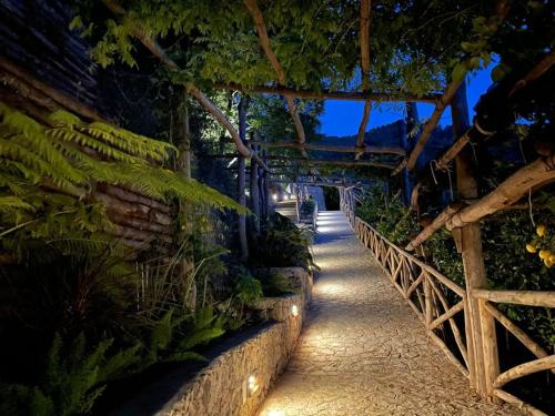 a walkway in a garden with a fence and plants at L'Olearia Luxury Country Villa in Amalfi Coast in Maiori