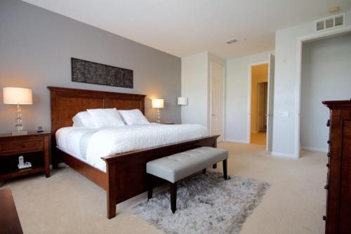 a large bedroom with a large bed and a bench at Shoreway Condo #231521 in Orlando