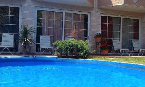 a large blue swimming pool in front of a house at Aloha Apartments with pool in Skopje