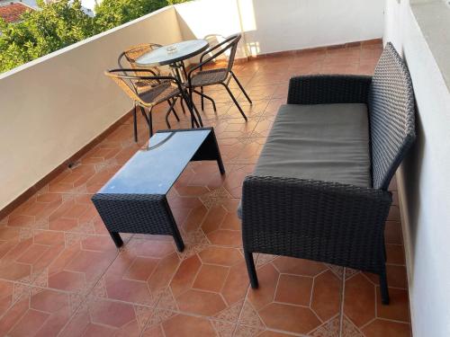 a balcony with chairs and a table and a bench at Apartments Dibra in Ulcinj