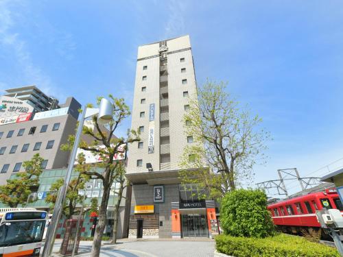 a tall building with a red train in front of it at APA Hotel Ogaki Ekimae in Ogaki