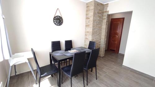 uma sala de jantar com uma mesa preta e cadeiras em Korzó Apartman Velence em Velence