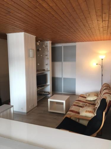 a living room with a couch and a table at APPARTEMENT DE MONTAGNE in Mijoux