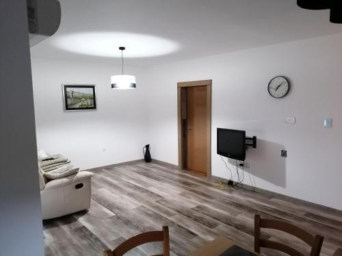 a living room with white walls and a tv at Jasna rooms in Ilirska Bistrica