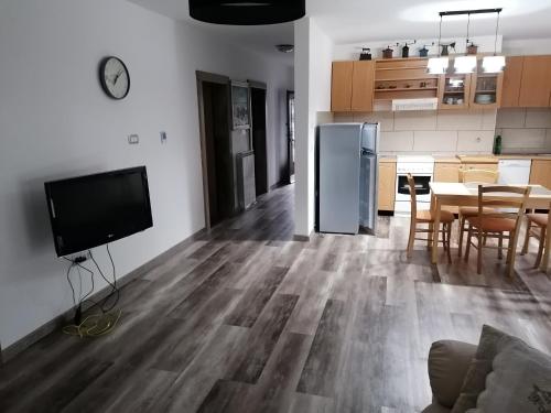 a kitchen and dining room with a refrigerator and a table at Jasna rooms in Ilirska Bistrica