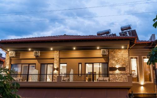 a house with a balcony at night at LYDIA suites and rooms in Litochoro