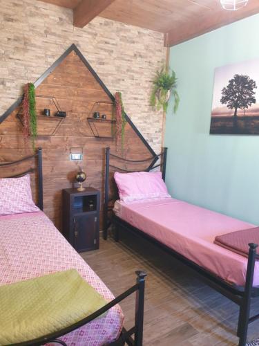 twee bedden in een kamer met een muur bij Stanza Del Viggiatore in Santadi
