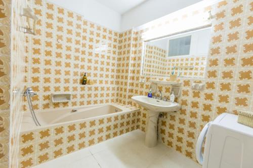 a bathroom with a bath tub and a sink and a bath tub at Varkiza Blue in Vari