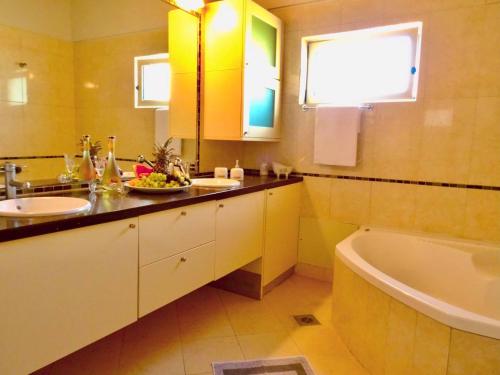 a bathroom with a tub and a sink and a bath tub at Filema Luxury Villa in Hersonissos