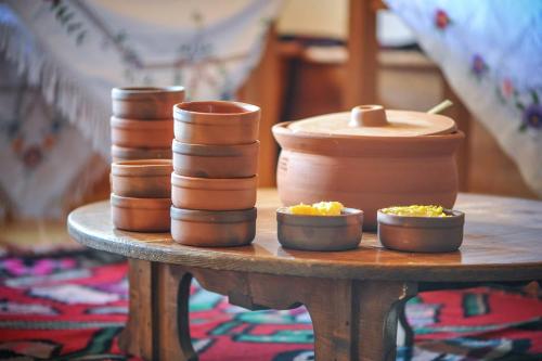 a table with pots and bowls on top of it at Guesthouse Letnja Basta in Lukomir