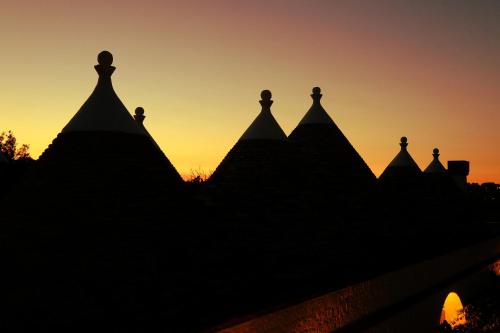 a silhouette of a pyramid at sunset at Masseria Trulli e Vigne in Martina Franca