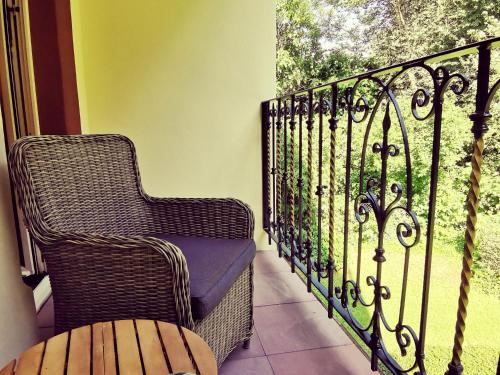 a wicker chair sitting on a balcony with a window at Hotel Erbprinzenpalais in Wernigerode