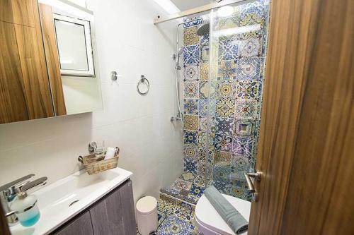 ein Bad mit einer Dusche, einem WC und einem Waschbecken in der Unterkunft Sophie's Apartment 1&2 in Poros