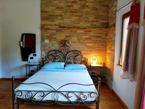CepagattiにあるCasale del Soleのレンガの壁のドミトリールームのベッド1台分です。