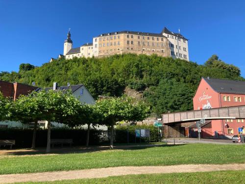 a tall building on top of a hill with houses at Ferienwohnung Prüfer in Greiz