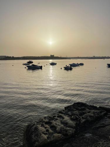 a group of boats in the water at sunset at Sunset Modern Apt near the beach in Birżebbuġa