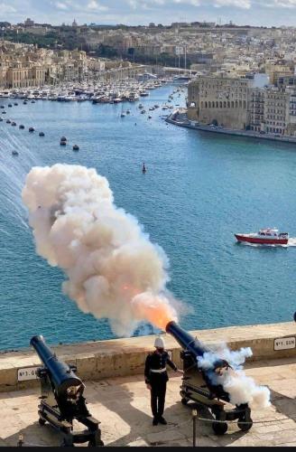a man holding a cannon with a cloud of smoke at Sunset Modern Apt near the beach in Birżebbuġa