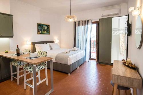 Schlafzimmer mit einem Bett, einem Tisch und einem Schreibtisch in der Unterkunft Sophie's Apartment 1&2 in Poros