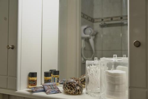 a bathroom counter with a mirror and toiletries at tripoli center apartment in Tripoli