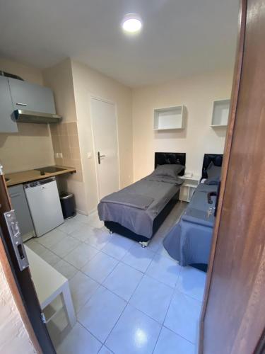 Cet appartement comprend une chambre avec deux lits et une cuisine. dans l'établissement RENT APPART - La Garenne Colombes, à La Garenne-Colombes