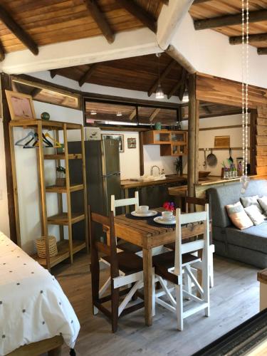 a kitchen and living room with a table and chairs at Ginger Studio in Santa Teresa Beach