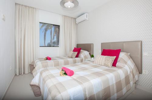 2 bedden in een kamer met roze kussens bij PLAYA CHICA by Buenavilla in Puerto del Carmen