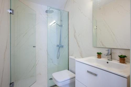 een badkamer met een douche, een toilet en een wastafel bij PLAYA CHICA by Buenavilla in Puerto del Carmen