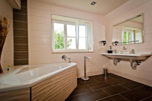 a bathroom with a tub and a sink at Bergrestaurant Schwedenstein in Steina