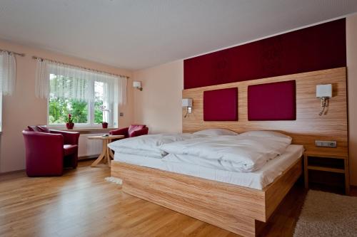 a bedroom with a large bed with a wooden headboard at Bergrestaurant Schwedenstein in Steina