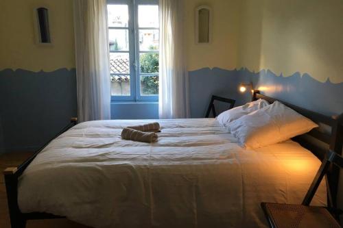 un grand lit blanc dans une chambre avec une fenêtre dans l'établissement Romantic house - entrance to the medieval castle, à Carcassonne