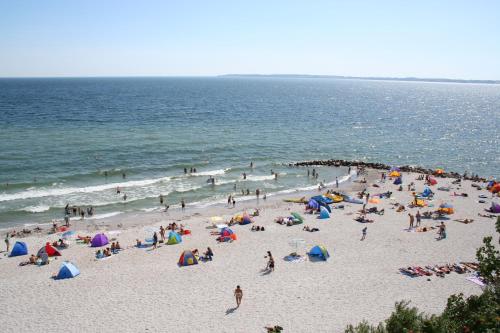 a group of people on a beach with the ocean at Ostsee Ferienhäuser in Waabs
