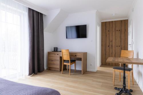 a bedroom with a desk and a table with chairs at Gościnny Dom Nad Morzem in Mielenko