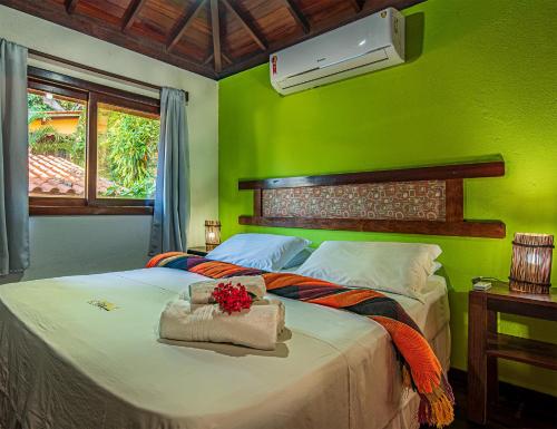 a bedroom with a bed with a green wall at Areia Branca Apart Hotel in Morro de São Paulo