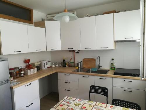 a kitchen with white cabinets and a table at B & B Color Rovereto in Rovereto