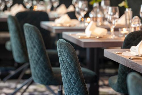 a row of tables in a restaurant with green chairs at Hotel Platzer Superior in Gerlos