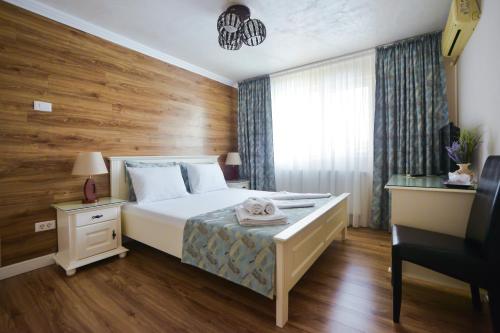 1 dormitorio con 1 cama con pared de madera en Pensiunea Ovidiu, en Crisan