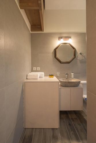 a bathroom with a sink and a mirror at Pink Sand Villas in Agios Padeleimon