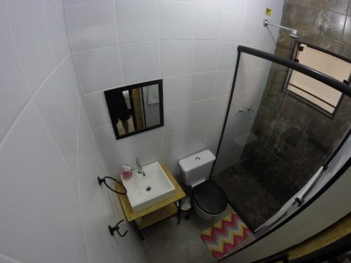 y baño con aseo, lavabo y ducha. en Like a Hostel, en Poços de Caldas